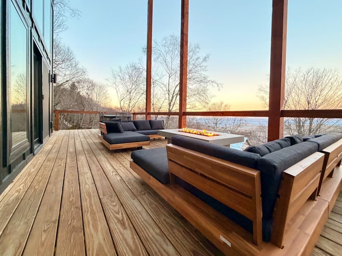 Mountain rental deck at sunset with a fire table and long-range views