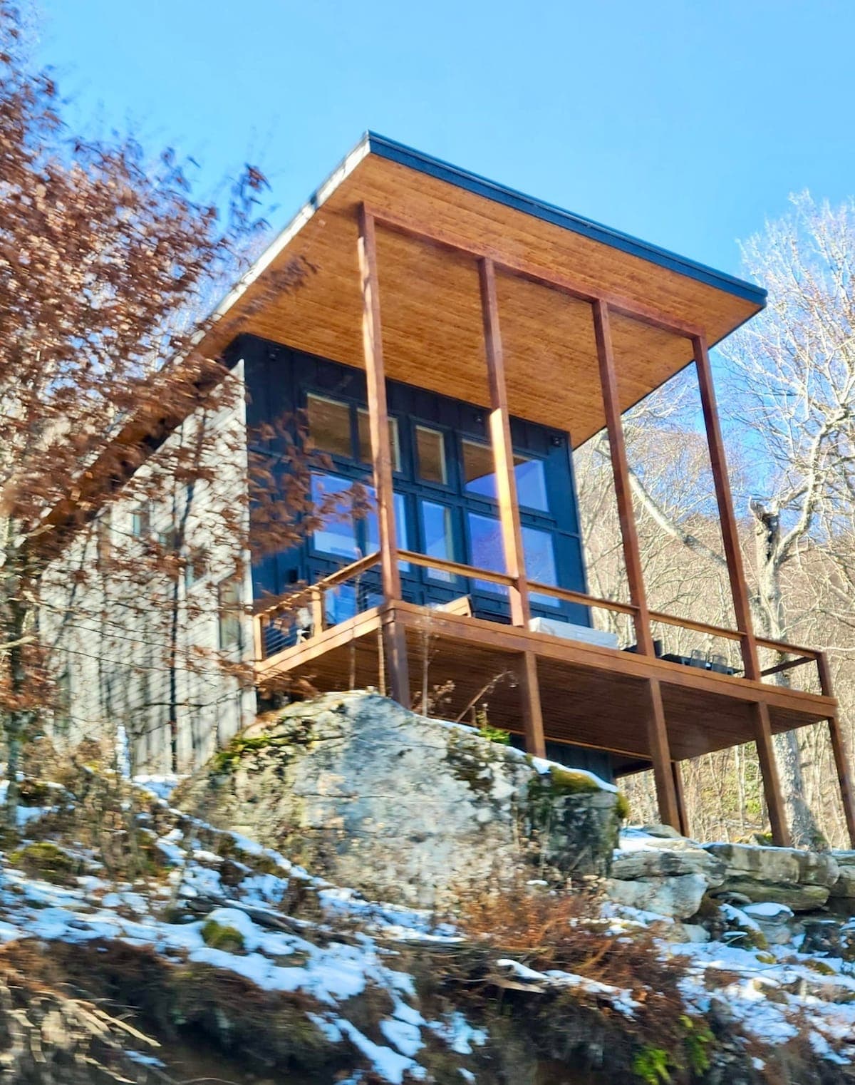 Exterior of a modern mountain rental perched on a rock ledge